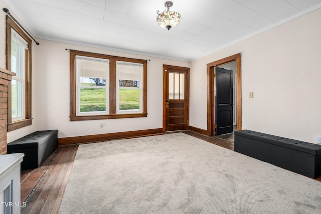 unfurnished living room featuring crown molding and dark wood-type flooring