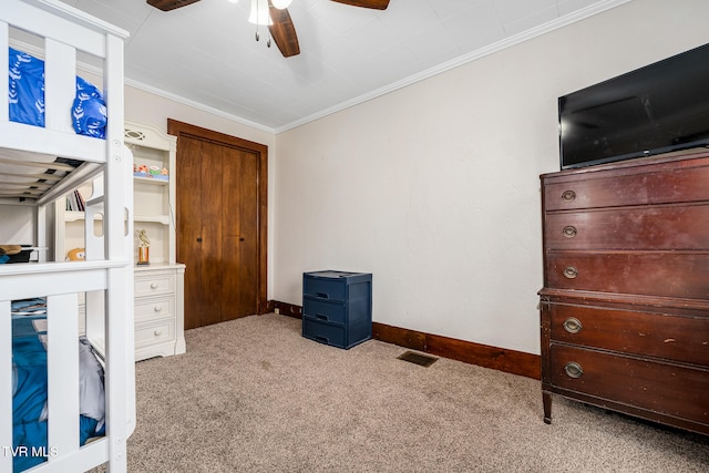 carpeted bedroom with ceiling fan and crown molding