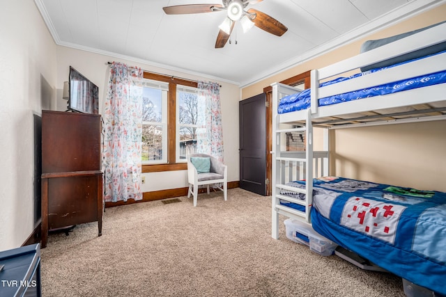 carpeted bedroom featuring ceiling fan and crown molding