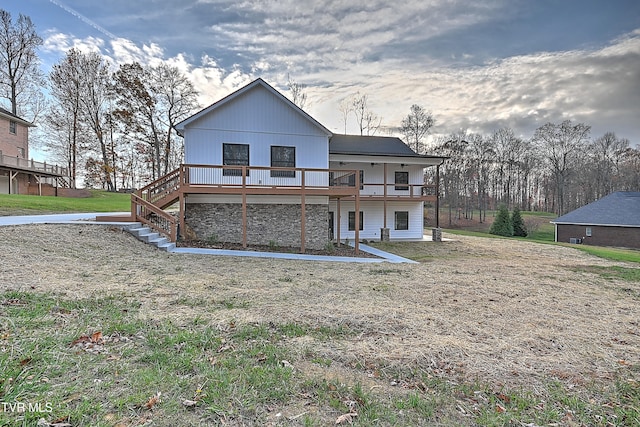 rear view of house with a lawn and a wooden deck