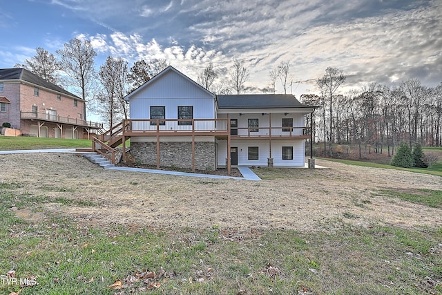 rear view of house with a deck and a lawn