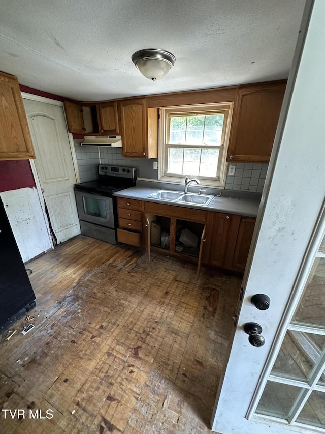 kitchen featuring stainless steel range with electric stovetop, backsplash, sink, dark hardwood / wood-style floors, and a textured ceiling