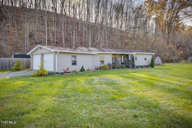 ranch-style home with a porch, a garage, a front yard, and a storage shed