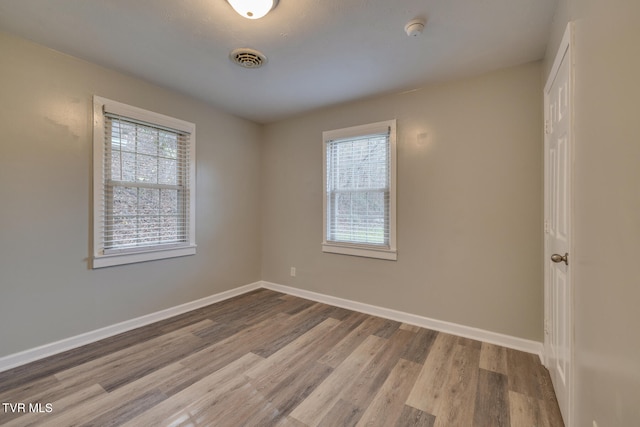 spare room featuring light wood-type flooring and a wealth of natural light