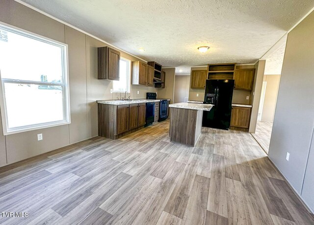 307 Bungalow Dr, Dandridge, TN 37725 - kitchen featuring sink, a center island, light hardwood / wood-style flooring, a textured ceiling, and black appliances
