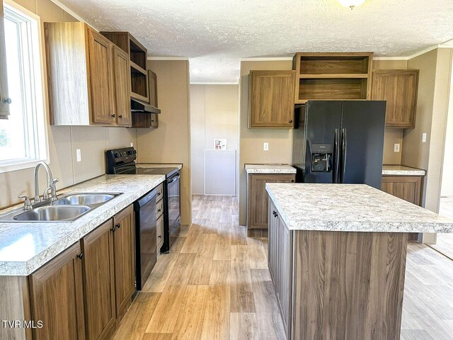 307 Bungalow Dr, Dandridge, TN 37725 - kitchen with ornamental molding, sink, black appliances, a center island, and light hardwood / wood-style floors
