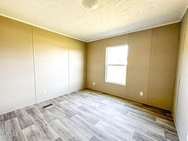 307 Bungalow Dr, Dandridge, TN 37725 - unfurnished room featuring a textured ceiling, light hardwood / wood-style floors, and crown molding