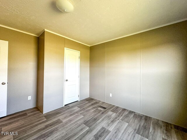 307 Bungalow Dr, Dandridge, TN 37725 - unfurnished bedroom featuring a textured ceiling, hardwood / wood-style flooring, and crown molding