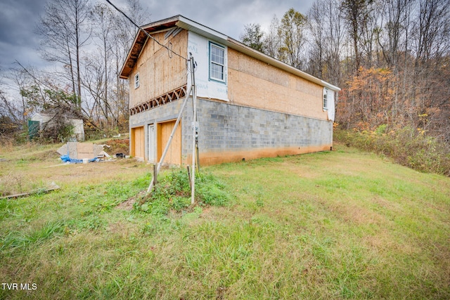 view of side of home featuring a yard and a garage