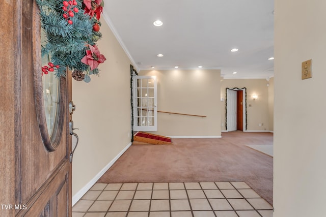 foyer entrance with light carpet and crown molding