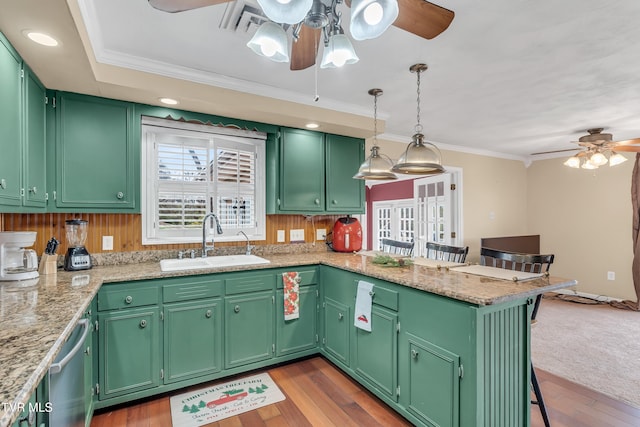 kitchen with sink, dark wood-type flooring, kitchen peninsula, a breakfast bar area, and green cabinetry