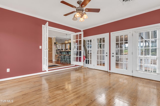 unfurnished room with crown molding, ceiling fan, french doors, and wood-type flooring