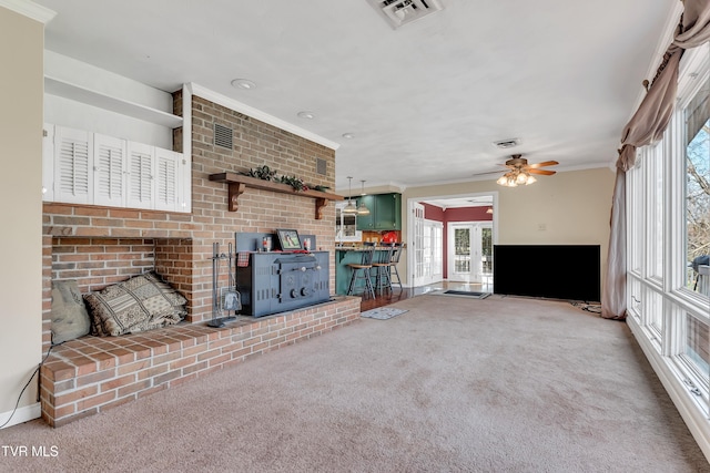 unfurnished living room featuring carpet flooring, french doors, ceiling fan, and crown molding