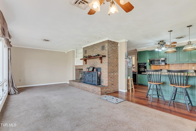 unfurnished living room featuring dark hardwood / wood-style floors, ceiling fan, a wood stove, and crown molding