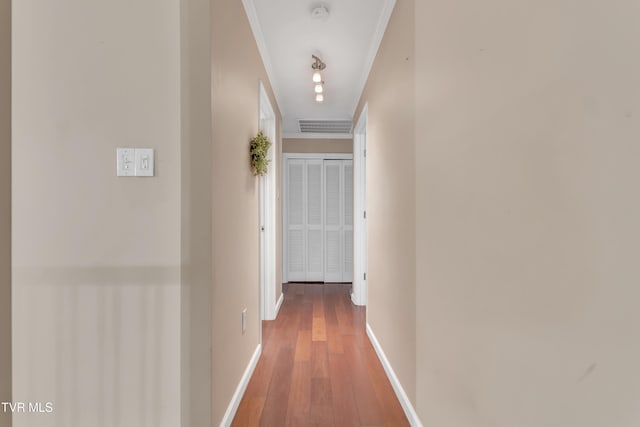 corridor with hardwood / wood-style flooring and ornamental molding