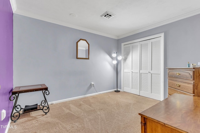 carpeted bedroom featuring crown molding and a closet