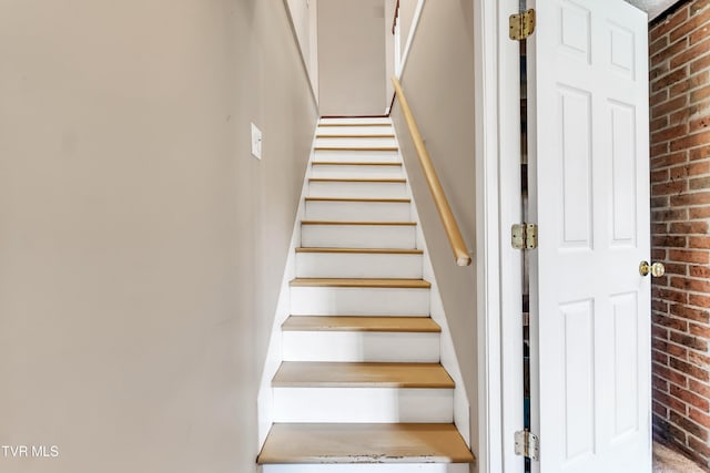 stairs featuring brick wall