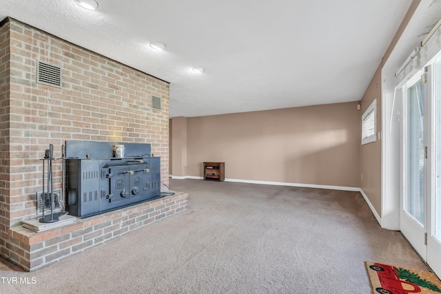 unfurnished living room featuring carpet flooring and a textured ceiling