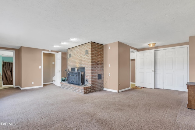 unfurnished living room featuring carpet flooring, a textured ceiling, and a wood stove