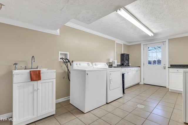 washroom featuring cabinets, a textured ceiling, crown molding, washing machine and clothes dryer, and light tile patterned flooring