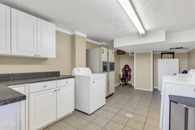 washroom with light tile patterned flooring, a textured ceiling, and washer / clothes dryer