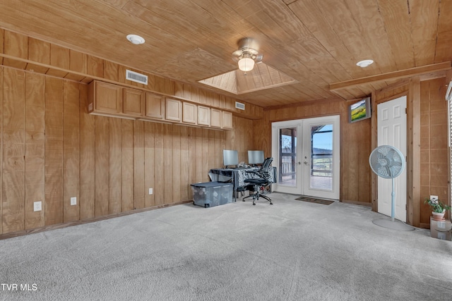 unfurnished office with wooden ceiling, french doors, wooden walls, ceiling fan, and carpet floors