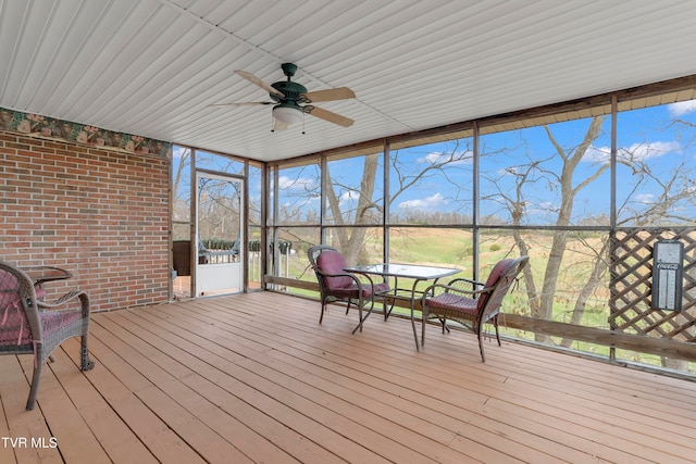 unfurnished sunroom with ceiling fan