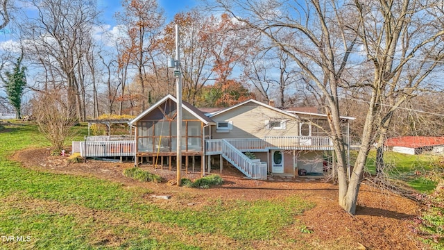 rear view of house with a wooden deck and a sunroom