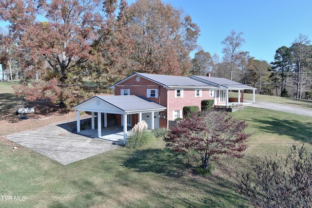 rear view of house featuring a carport and a lawn