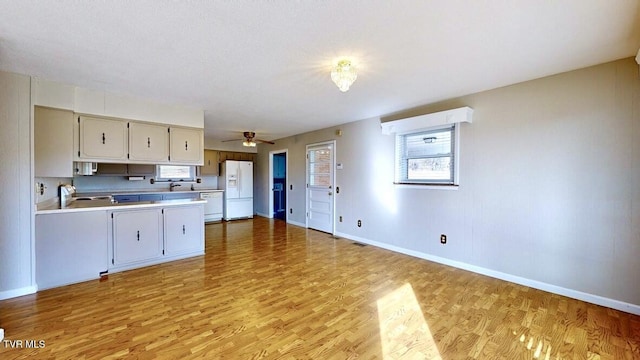 kitchen with ceiling fan, light hardwood / wood-style flooring, white appliances, and sink