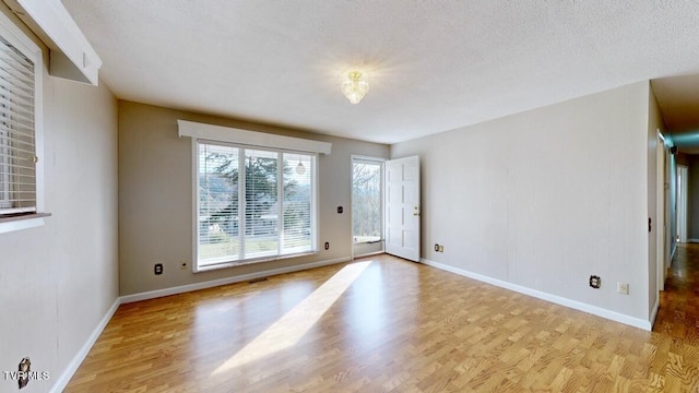 doorway with light hardwood / wood-style flooring and a textured ceiling