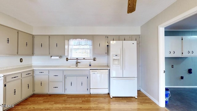 kitchen with white appliances, light hardwood / wood-style flooring, and sink