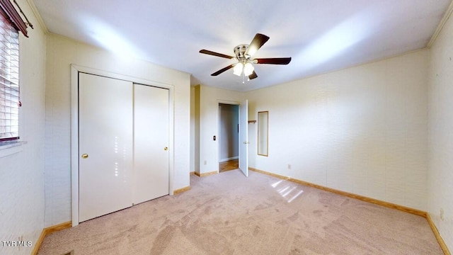 unfurnished bedroom with multiple windows, ceiling fan, a closet, and light colored carpet