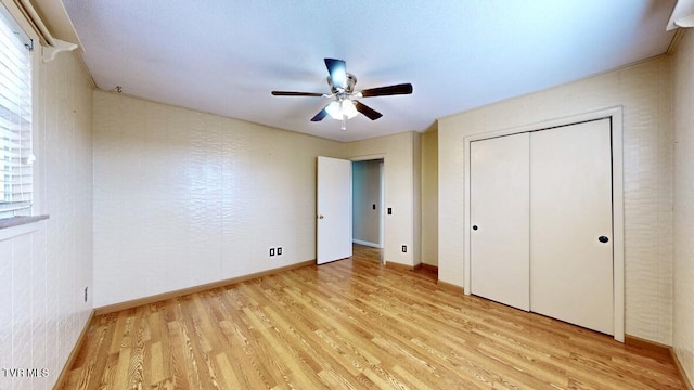 unfurnished bedroom with light wood-type flooring, a closet, and ceiling fan