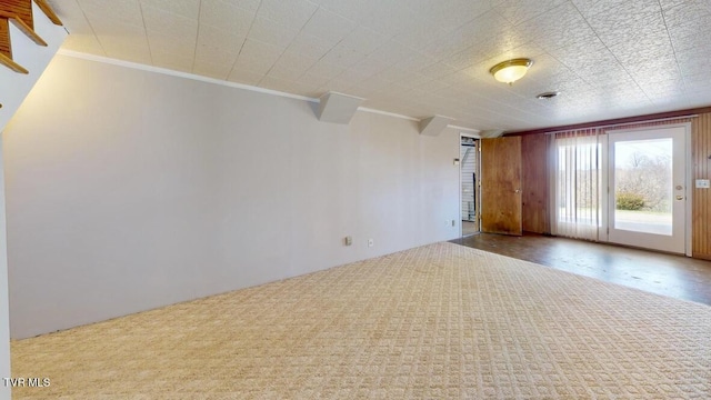 carpeted empty room featuring crown molding