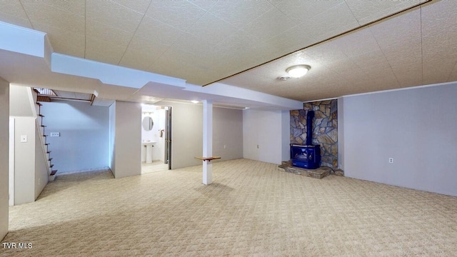 basement with carpet and a wood stove