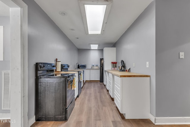 106 W Sycamore Ave, Big Stone Gap, VA 24219 - kitchen featuring black appliances, white cabinets, and light wood-style floors