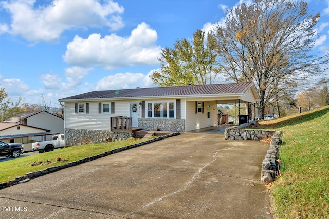 ranch-style house featuring metal roof, a front lawn, concrete driveway, and a carport