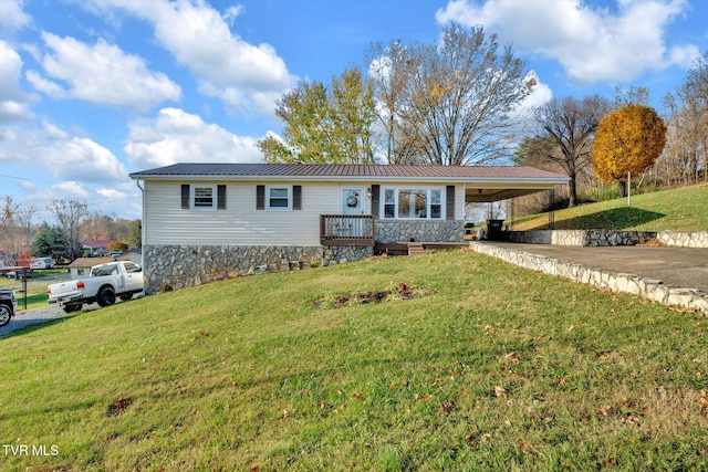 ranch-style home featuring a front lawn, a deck, and a carport