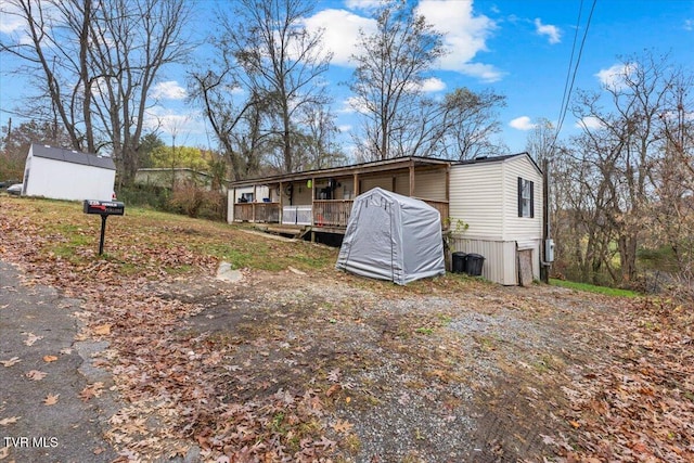 view of front of home with covered porch and a storage unit