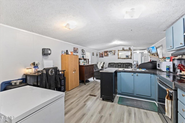 kitchen featuring a textured ceiling, stainless steel electric stove, sink, light hardwood / wood-style floors, and lofted ceiling