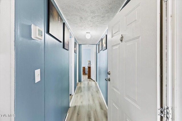 hallway featuring a textured ceiling and light wood-type flooring