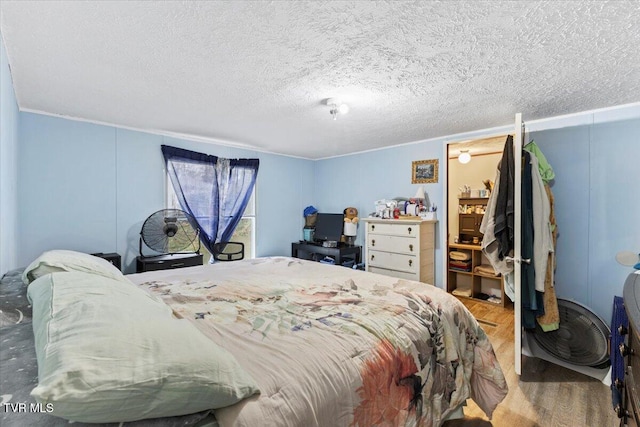 bedroom with hardwood / wood-style floors and a textured ceiling