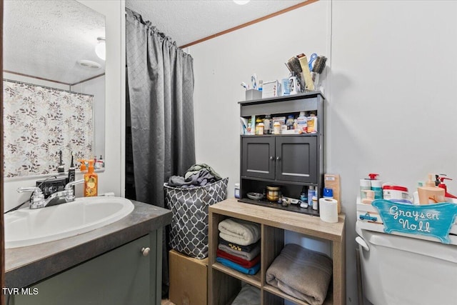 bathroom featuring walk in shower, a textured ceiling, toilet, vanity, and ornamental molding