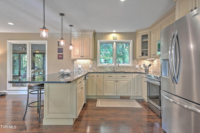 kitchen featuring a kitchen bar, cream cabinets, and stainless steel appliances