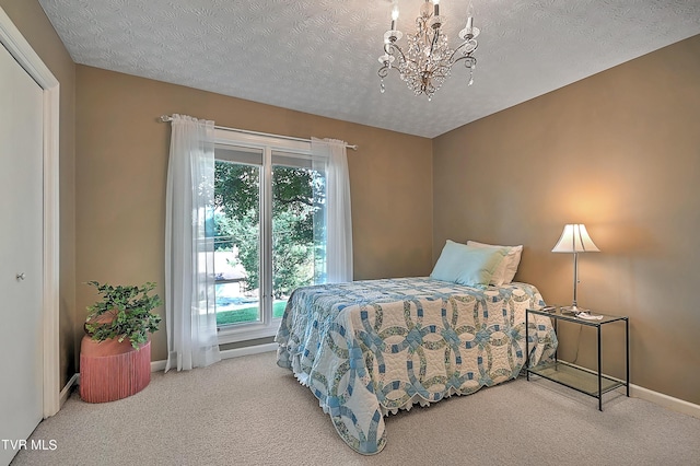 carpeted bedroom featuring a textured ceiling and an inviting chandelier