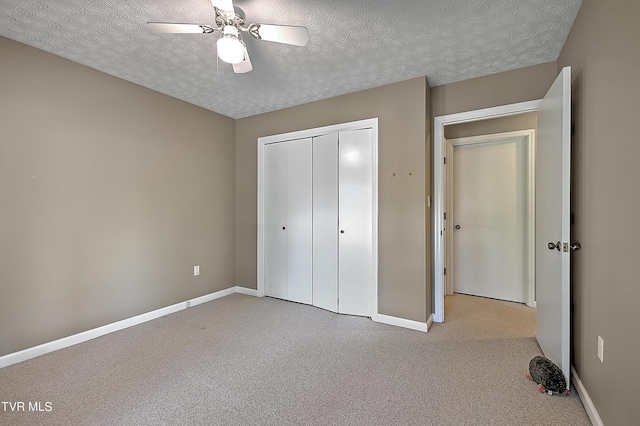 unfurnished bedroom with light carpet, a textured ceiling, a closet, and ceiling fan