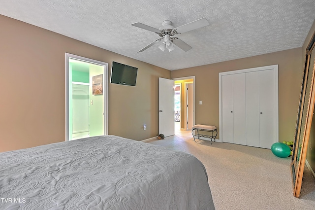 bedroom featuring a textured ceiling, light colored carpet, and ceiling fan