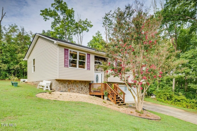 raised ranch featuring a garage and a front yard