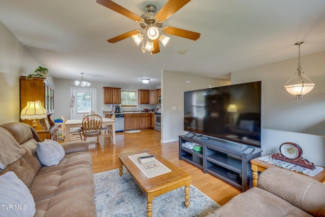 living room featuring ceiling fan, light wood-type flooring, and baseboards